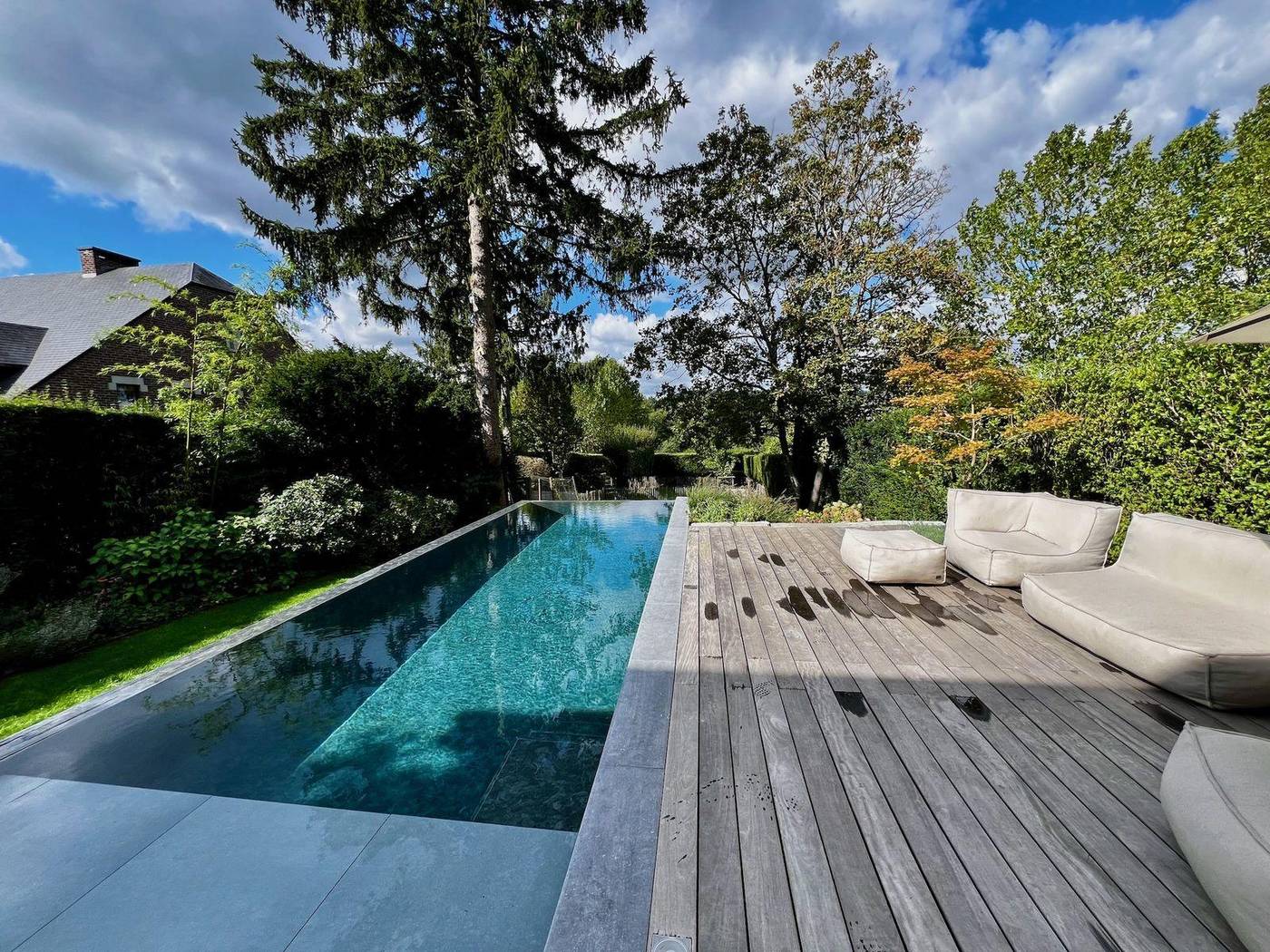 Bassin et terrasse en bois entourés de plantations