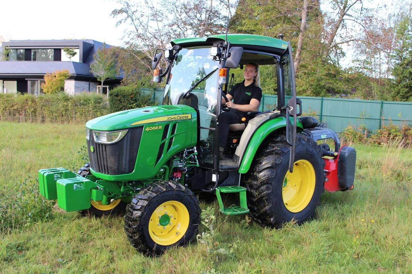 Tracteur vert avec broyeur porté dans une prairie